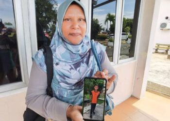 Al Miahnor Ali menunjukkan gambar anaknya, Abdul Rafiuddin Abdul Rashid yang ditemukan lemas di Sungai Dungun dekat Kampung Rajawali, Dungun, hari ini. - UTUSAN/NIK NUR IZZATUL HAZWANI NIK ADNAN