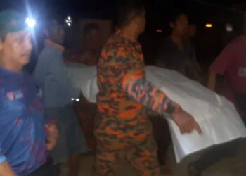 ANGGOTA pasukan penyelamat mengusung mayat Abdul Rafiuddin Abdul Rashid yang ditemukan lemas di Sungai Dungun dekat Kampung Rajawali, Dungun, hari ini. - IHSAN BOMBA
