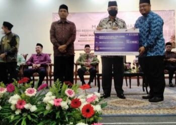 MOHAMAD Rizam (dua dari kanan) menyampaikan replika cek sumbangan Fidyah kepada salah seorang Imam di Kompleks Islam Jubli Perak, Panji, Kota Bharu, Kelantan.UTUSAN/ROHANA MOHD.NAWI