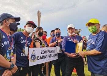 BUNG Moktar (kanan) menyampaikan sijil penyertaan kepada pasukan bola sepak yang bertanding dalam Piala Datuk Seri Bung Moktar Radin di Kota Kinabalu