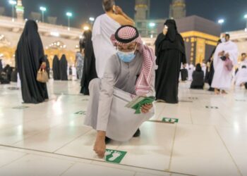 PETUGAS di Masjidilharam menanggalkan pelekat yang mengingatkan orang ramai supaya menjaga jarak ketika solat sebelum ini. - ARAB NEWS
