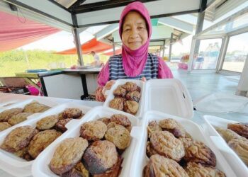 NIK Hamidah Nik Man menunjukkan akok hasil air tangannya yang dijual di Pasar Siti Hajar, Pasir Puteh. - UTUSAN/TOREK SULONG