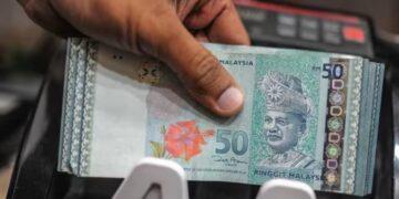 RAKYAT Singapura memanfaatkan kejatuhan Ringgit Malaysia untuk mendapat produk dan bekalan pada harga lebih murah.-AFP