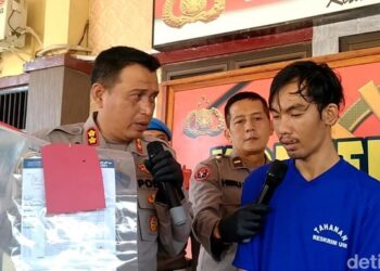SUSPEK (berbaju biru) kini ditahan polis bagi membantu siasatan. - AGENSI