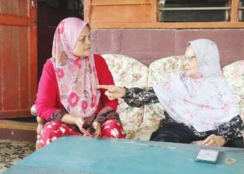 HAWA Deraman (kanan) bercerita kisah kekejaman komunis kepada anak saudaranya, Zamiah Abd. Rahim di Kampung Batu Bor di Bera, Pahang. - UTUSAN/SALEHUDIN MAT RASAD