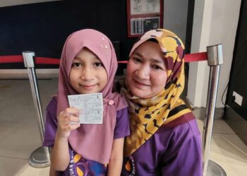 NUR Qistina Batrisyia Mohd. Zamri menunjukkan tiket filem Air Force The Movie: Selagi Bernyawa bersama Juriah Saad di Seberang Jaya, Pulau Pinang semalam.