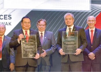 Ketua Pegawai Petros, Janin Girie (dua dari kiri) dan Adif Zulkifli (dua dari kanan) menunjukkan dokumen perjanjian antara Petronas dan Petros sambil disaksikan oleh Premier Sarawak, Tan Sri Abang Johari Tun Openg.
