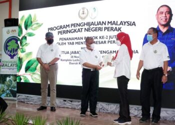 SAARANI Mohamad (dua dari kiri) menyampaikan sijil penanaman pokok kepada wakil jabatan pada Program Penghijauan Malaysia Peringkat Negeri Perak di Kompleks Latihan Perhutanan Sungai Siput hari ini. - UTUSAN/ZULFACHRI ZULKIFLI