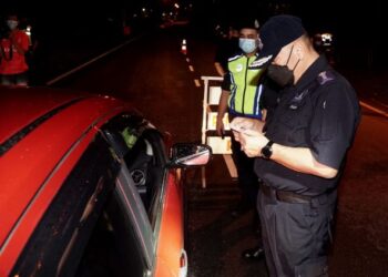 MIOR Faridalathrash Wahid memeriksa lesen memandu pemandu kenderaan pada Op Cegah Jenayah Khas Kontinjen Perak di Ipoh semalam. - UTUSAN/ZULFACHRI ZULKIFLI