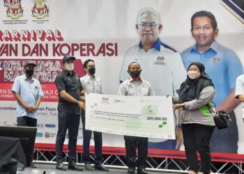 MOHD. SHAHAR Abdullah (dua, kiri) menyampaikan replika geran program tunas usahawan belia bumiputera pada Karnival Usahawan dan Koperasi Keluarga Malaysia, di Kuantan, Pahang. - UTUSAN/ DIANA SURYA ABD WAHAB
