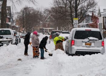 PENDUDUK mengorek salji yang menyebabkan kereta terperangkap di Buffalo, New York.-AFP