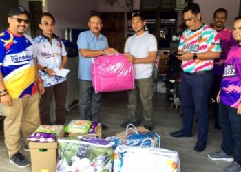RUSLIN Jusoh (tiga dari kiri) menyampaikan bantuan banjir kepada salah seorang kakitangan JPN Terengganu yang terlibat banjir di Taman Desa Tanjung Damai, Kuala Nerus, Terengganu, hari ini. - UTUSAN/ TENGKU DANISH BAHRI TENGKU YUSOFF
