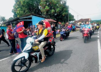 SULTAN Ibrahim dan Tuanku Raja Zarith Sofiah menunggang motosikal untuk mendekati rakyat dalam program Kembara Mahkota Johor. 
– UTUSAN