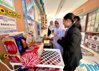 NORYAH Md. Noh melihat para pelajar menyediakan makanan yang disediakan secara percuma sepanjang tempoh mereka menduduki peperiksaan SPM di SMK Arau, Perlis hari ini.- UTUSAN/MOHD. HAFIZ ABD. MUTALIB