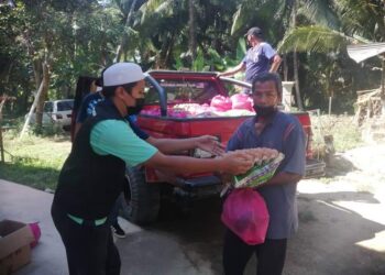 SUKARELAWAN Ihsan mengagihkan makanan dan barangan dapur kepada orang ramai yang terkesan akibat pandemik di sekitar Tumpat.