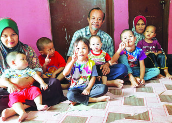 CHE Norazimah Mohd. Radzi (kiri) bersama bapa, Mohd. Radzi Sulung dan ibu, Che Yati Che Jan serta tiga anak dan sebahagian adik-adiknya ketika ditemui di Kampung Sungai Pasir Luar, Terap di Kulim. – UTUSAN/AZAHAR HASHIM