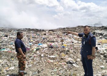 ANGGOTA Jabatan Bomba dan Penyelamat Malaysia (JBPM) Kelantan melakukan pemantauan di kawasan kebakaran di tapak pelupusan sampah di Kampung Kok Bedollah, Tumpat, Kelantan. -UTUSAN/ROHANA ISMAIL