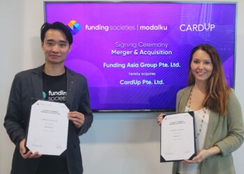 Kelvin Teo (kiri) dan Pengasas dan Ketua Pegawai Eksekutif CardUp, Nicki Ramsay, menunjukkan dokumen pengambilalihan CardUp.