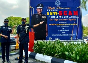 ARJUNAIDI Mohamed (kanan) menunjukkan papan tanda kempen Anti-Scam Peringkat Kontinjen Selangor yang dicetak sebanyak 392 unit untuk diedar di seluruh negeri ini, di Shah Alam, Selangor.
