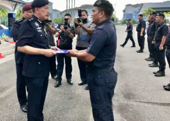 MUHAMAD Zaki  Harun (kiri) menyampaikan sijil penghargaan kepada anggota di padang kawat Batalion 8 Pasukan Gerakan Am (PGA) di Pengkalan Chepa, Kota Bharu, Kelantan, semalam. / FOTO ROSLIZA MOHAMED