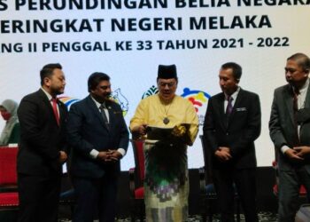 SULAIMAN Md. Ali (tengah) melihat buku persidangan selepas merasmikan Majlis Perundingan Belia Negara Peringkat Negeri di Ayer Keroh, Melaka. - UTUSAN/MUHAMMAD SHAHIZAM TAZALI