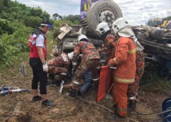 ANGGOTA bomba mengeluarkan mangsa yang tersepit dalam kemalangan di Kilometer 390, Lebuh Raya Utara-Selatan arah utara dekat Tanjung Malim hari ini.  - UTUSAN/JBPM PERAK