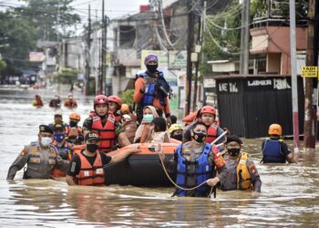 PASUKAN penyelamat memindahkan penduduk ke kawasan selamat selepas banjir melanda Bekasi, tahun lalu.-AFP