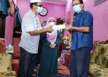 ABDUL RASHID Abdul Samad (kanan) menyerahkan sumbangan khairat kematian kepada Zulkeflee Zainol di Taman Penaga Permai, Kepala Batas, Pulau Pinang hari ini.