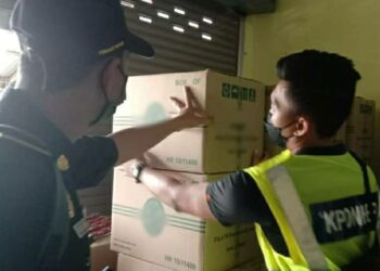 PEGAWAI penguatkuasa KPDNHEP memeriksa kotak-kotak yang mengandungi produk minuman tiruan dalam serbuan di Kota Bharu dan Rantau Panjang, Kota Bharu, Kelantan semalam.UTUSAN/IHSAN KPDNHEP KELANTAN