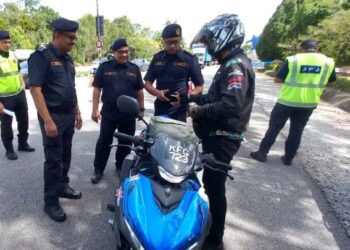 MUHAMMAD FIRDAUS Sharif (kiri) memeriksa seorang penunggang motosikal dalam Op Rentas Sempadan Wilayah Selatan di Pintu Gerbang Ayer Keroh, Melaka. - UTUSAN/AMRAN MULUP