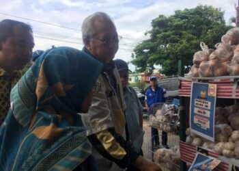 ANNUAR Musa (dua kiri) semasa memeriksa tanda harga pada Program Jualan Murah Keluarga Malaysia (PJMKM) Melor di Gudang Panji Makmur Trading di Melor, Kelantan hari ini.UTUSAN/ROSMIZAN RESDI