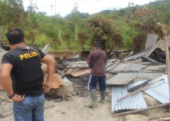 ANGGOTA POLIS melihat rumah yang dibakar dalam serangan keganasan di Lembantongoa, Sulawesi Tengah, Indonesia. - ANTARA FOTO