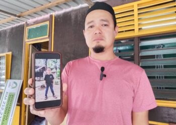 MUHAMMAD Izwan Ibrahim menunjukkan gambar Yusuf Daniel Muhammad Izwan ketika ditemui di kediamannya di Kampung Pondok Batang, Jasin, Melaka.