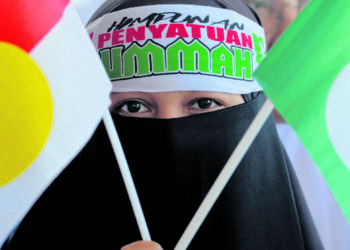 PENYOKONG penyatuan ummah menunjukkan bendera UMNO dan Pas pada Himpunan Penyatuan Ummah di ibu negara.