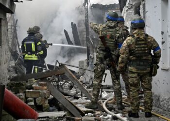 ANGGOTA pasukan penyelamat Ukraine memadam kebakaran di bangunan kediaman yang rosak teruk dibedil Russia di Kherson di selatan Ukraine.-AFP