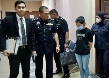 ERTUDUH, Nurima Juli semasa dibawa keluar dari Mahkamah Majistret Tawau hari ini.
