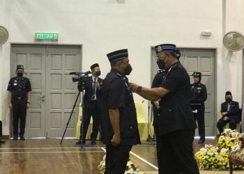 SHAFIEN Mamat memakaikan pingat Jasa Pahlawan Negara kepada seorang penerima di IPD Pasir Mas hari ini. - UTUSAN/ROSALWANI CHE SOH