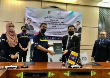 DR . Zulkifli Mohamed (dua kiri) dan Tuan Zainal Abidin Tuan Yusuf menunjukkan dokumen MoU antara UiTM dan MPKB-BRI di Dewan Bunga Raya MPKB-BRI, Kota Bharu hari ini. - UTUSAN/ROSLIZA MOHAMED
