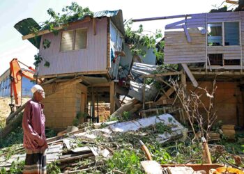 MOHAMED Jali melihat rumahnya yang musnah dihempap pokok semasa ribut di Kampung Pintu Geng, Kota Bharu. – UTUSAN/KAMARUL BISMI KAMARUZAMAN