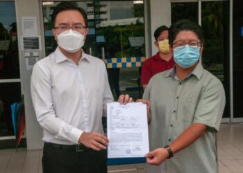 Ewon Benedick (kanan) bersama Phoong Jin Zhe selepas membuat laporan polis di Balai Polis Karamunsing di Kota Kinabalu hari ini