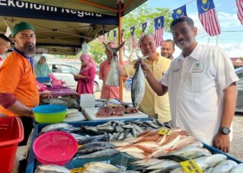 NUKMAN Hashim (kanan) meninjau gerai menjual ikan di program khas jualan terus dari ladang Keluarga Malaysia di Masjid Kubang Ikan, Kuala Terengganu, hari ini. - UTUSAN/KAMALIZA KAMARUDDIN