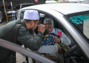 EBIT Lew mengucup dahi Nurainul Zahirah Rashidi,6, selepas menghadiahkan Perodua Viva kepada ibu kanak-kanak OKU itu, Azimah Abd. Rahim.
