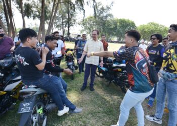 ANWAR Ibrahim beramah mesra bersama peserta program Sambutan Raya Mat Moto 1.0 di Port Dickson hari ini.-UTUSAN/MOHD. SHAHJEHAN MAAMIN