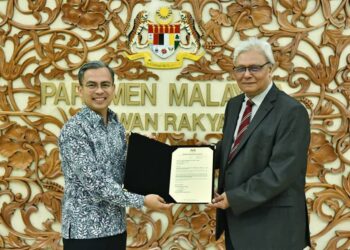 FAHMI Fadzil menyerahkan surat pelantikan Pengerusi baharu Finas kepada Kamil Othman di Parlimen. - FACEBOOK FAHMI FADZIL