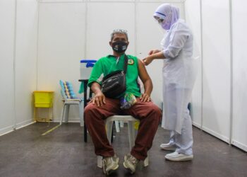 OHN Baharin Ayom ketika menerima suntikan vaksin Covid-19 di PPV Dewan Pejabat Daerah Jempol, Bandar Seri Jempol, Jempol hari ini.-UTUSAN/MUHAMMAD IZZAT TERMIZIE.