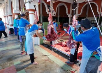 SEBILANGAN petugas sedang melapah daging korban dengan mematuhi prosedur operasi standard di Masjid Tengku Mahkota Abdullah di Jerantut, Pahang. - UTUSAN/HARIS FADILAH AHMAD