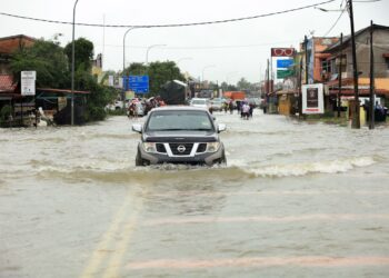 ANTARA jalan yang ditenggelami air di sekitar Kadok, Kota Bharu, Kelantan semalam.-UTUSAN/KAMARUL BISMI KAMARUZAMAN