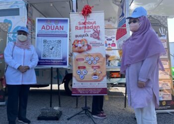 NORLELA ARIFFIN (kanan) merasmikan kod QR aduan sambil diperhatikan Dr. Fazilah Shaik Allaudin di bazar Ramadan Bertam Putra, Kepala Batas, Pulau Pinang semalam. - Pix: SITI NUR MAS ERAH AMRAN