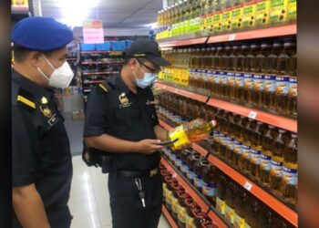 Pegawai penguatkuasa KPDNHEP Negeri Sembilan memeriksa bekalan minyak masak di sebuah kedai di bandar Seremban semalam.