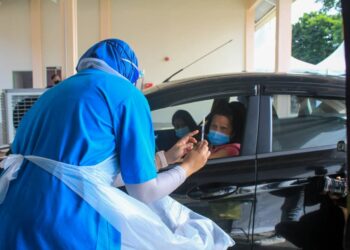 SALAH seorang warga emas bersedia untuk menerima vaksin Covid-19 di Pusat Pemberian Vaksin (PPV) pandu lalu di Universiti Sains Malaysia (USM), Pulau Pinang.